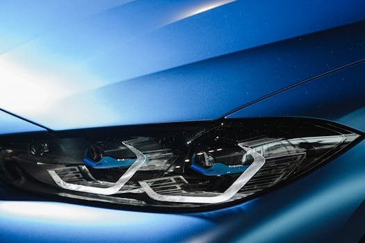 Close-up image of a modern car's sleek blue headlight. Perfect for automotive design enthusiasts.